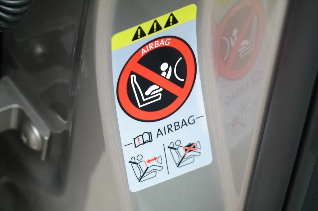 Zdjęcia przedstawiają etykiety naklejone w różnych częściach pojazdów, gdzie służą jako tabliczki znamionowe.